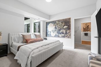 a bedroom with a bed and a large painting on the wall